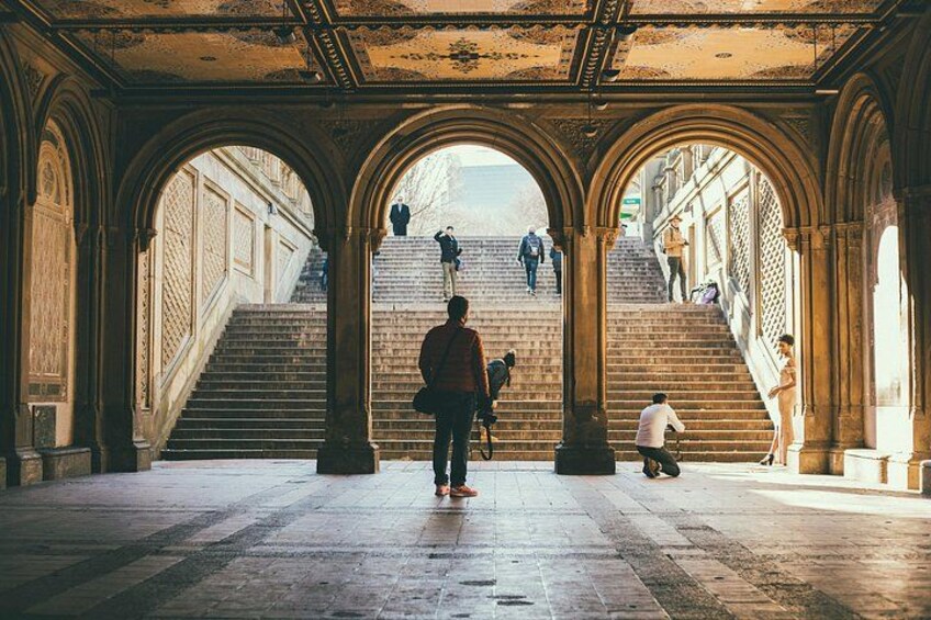 A historical building with arched walkways and a staircase leading to an upper level. 2