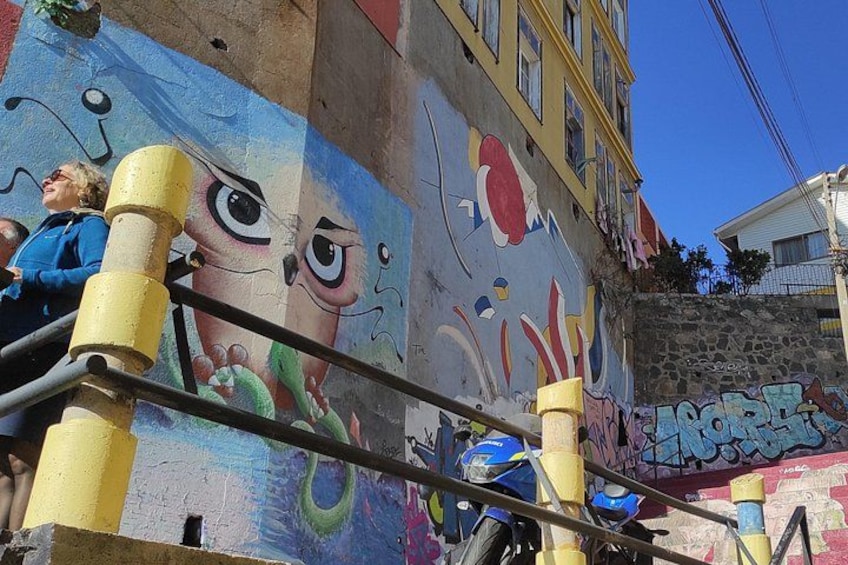 A mural with large eyes and abstract shapes on a building wall. 5