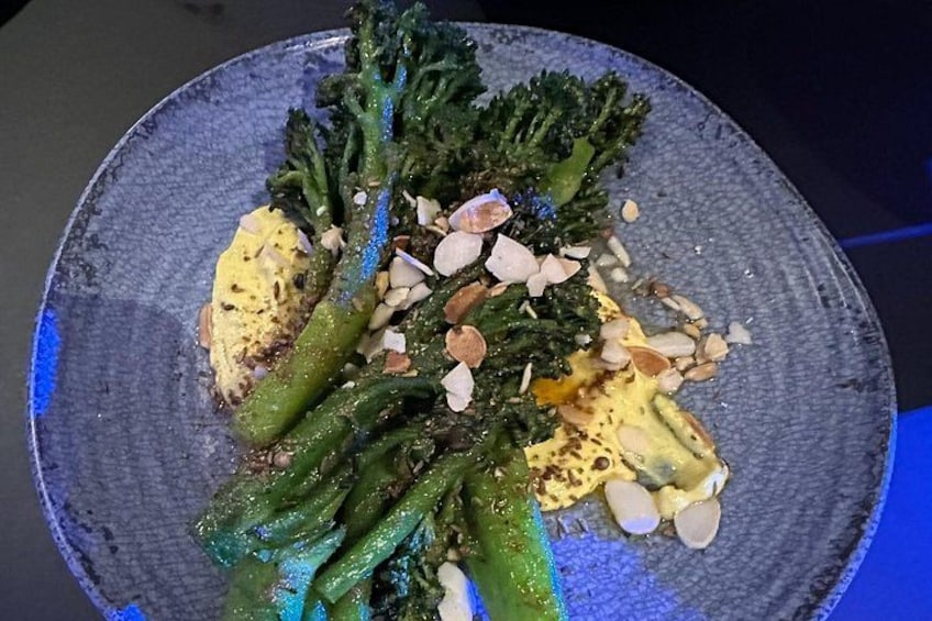 Un plato de comida con brócoli y almendras. 2
