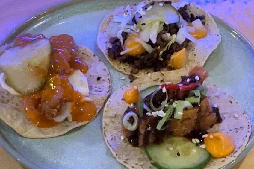 Tres tacos en un plato con diferentes ingredientes. 4