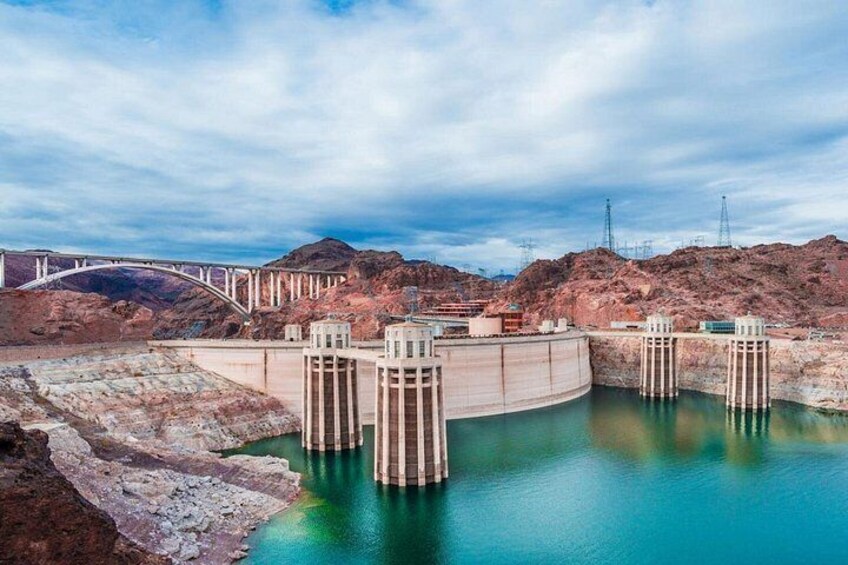 A dam with water gates, a bridge, and a mountainous landscape. 2