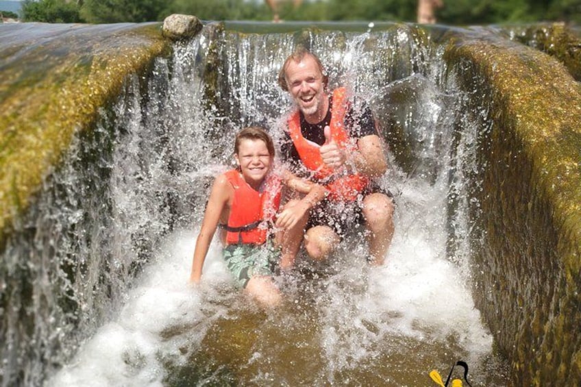 A waterfall with people enjoying the water. 1