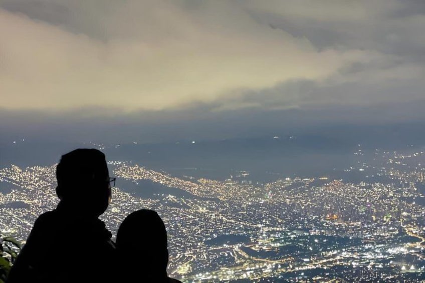 A silhouette of a person overlooking a cityscape at dusk. 5