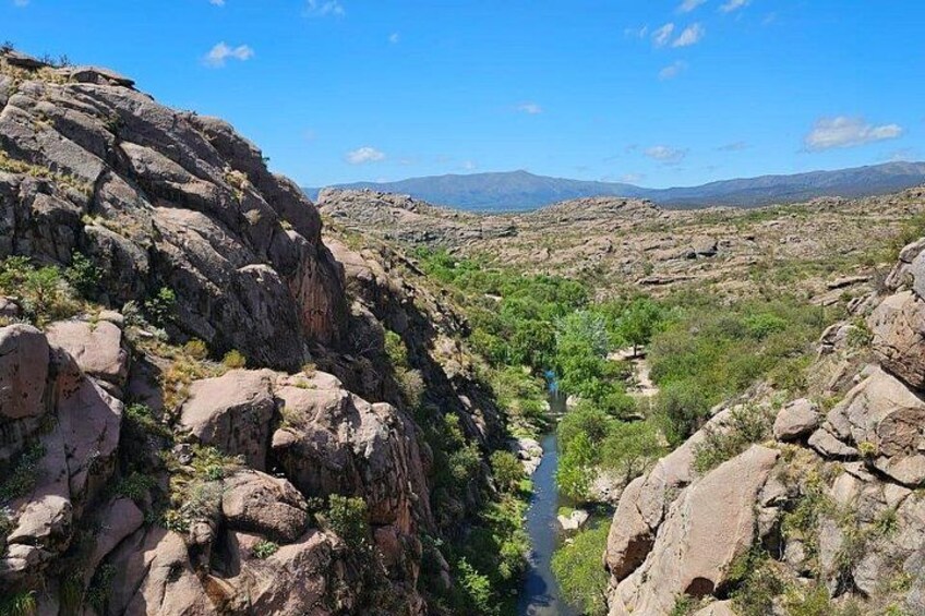 A canyon with rocky terrain and a river. 1