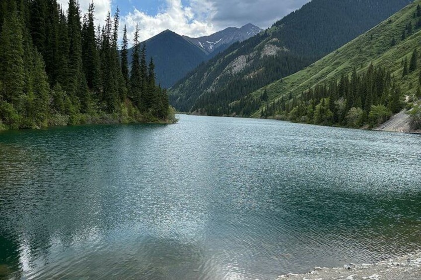 A calm lake surrounded by dense forests and mountains. 3