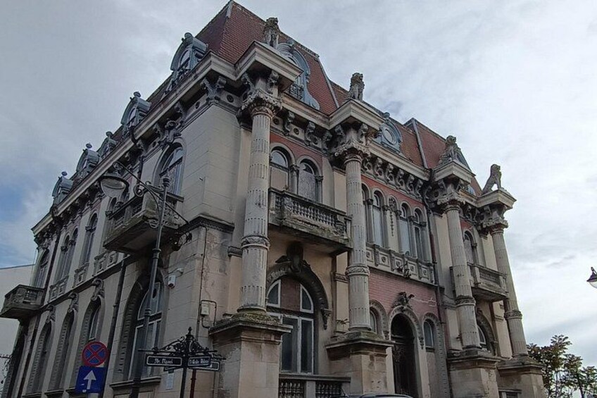 A historic building with ornate architecture, including columns, arches, and statues. 5