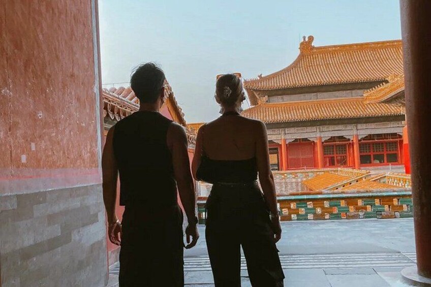 Ein Paar steht vor einem traditionellen chinesischen Gebäude mit einem Ziegeldach. 2