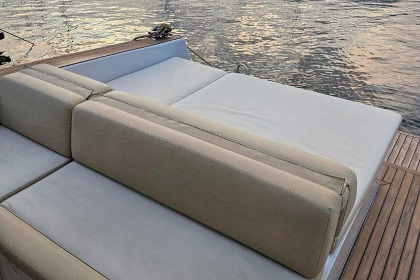 Un bote con un banco acolchado color beige y una cubierta blanca. 2