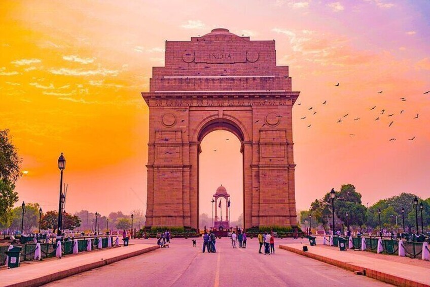 The India Gate with a sunset sky, a large archway, and a dome in the background. 3