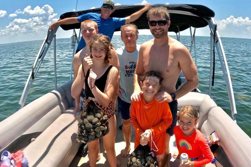 A group of people on a boat with a clear sky and calm sea. 3