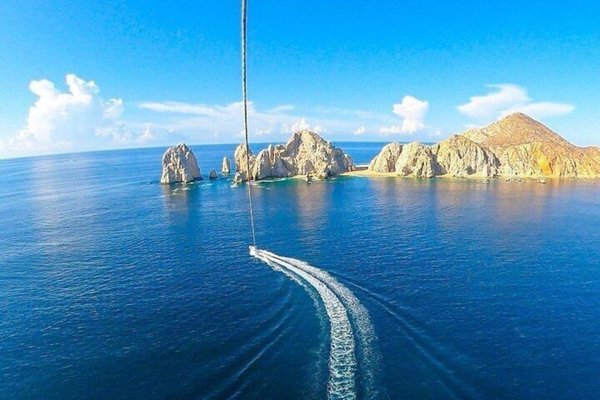 A sailboat on a calm sea with rocky outcrops in the distance. 5