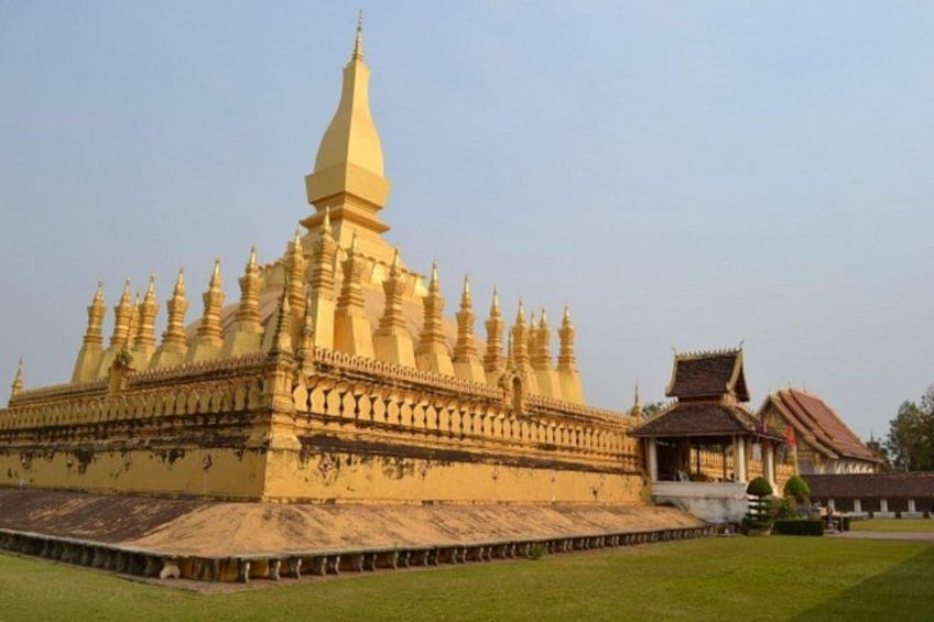 A large, ornate temple with multiple spires and a central stupa, surrounded by a well-maintained lawn. 1