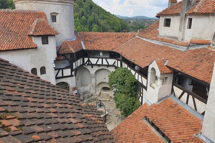 A historic town with red-tiled roofs, white buildings, and a central courtyard. 1