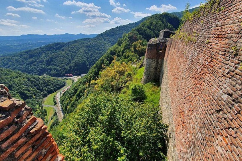 A brick wall, a valley, and a distant mountain range. 3