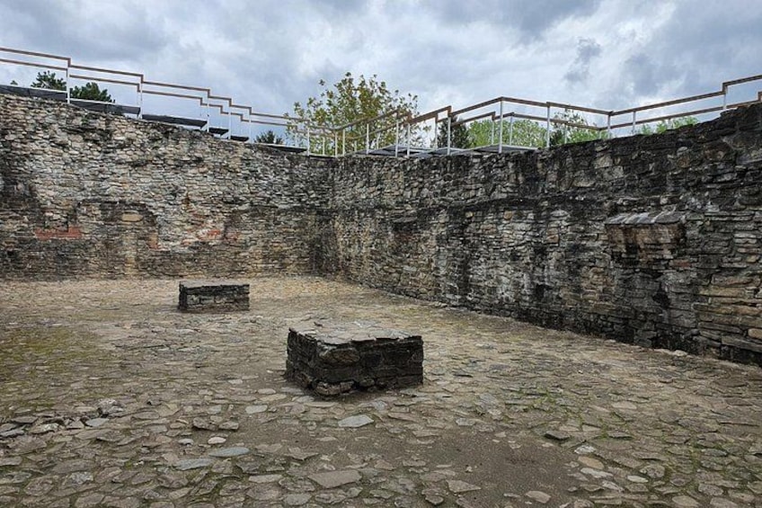 An ancient stone structure with a stone floor and a stone wall. 5