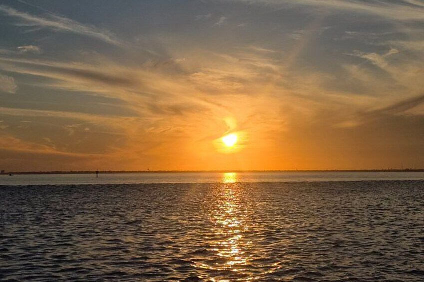 Ein Sonnenuntergang über einem Gewässer bei klarblauem Himmel. 5