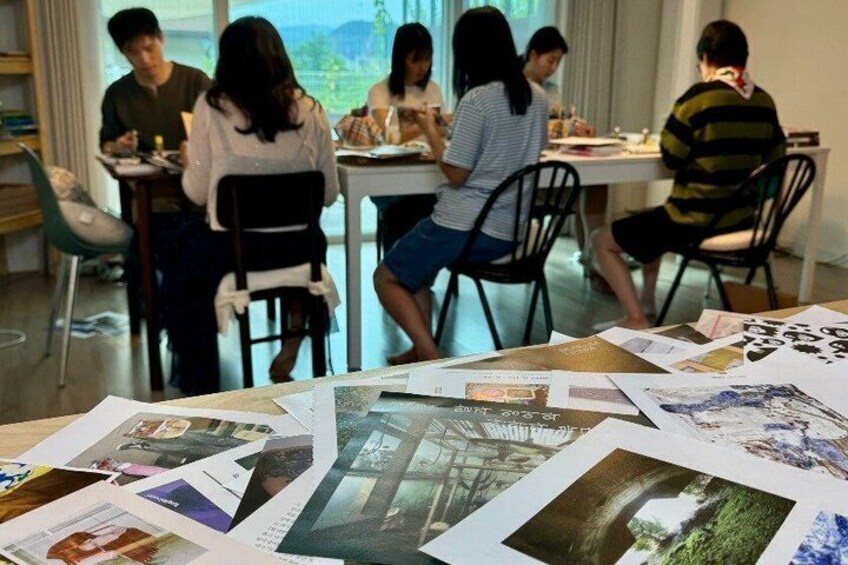 A group of people seated around a table with papers and photographs spread out. 5
