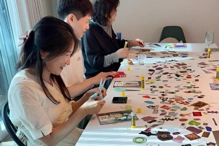 People engaged in a craft activity with various colored papers and art supplies on a table. 3