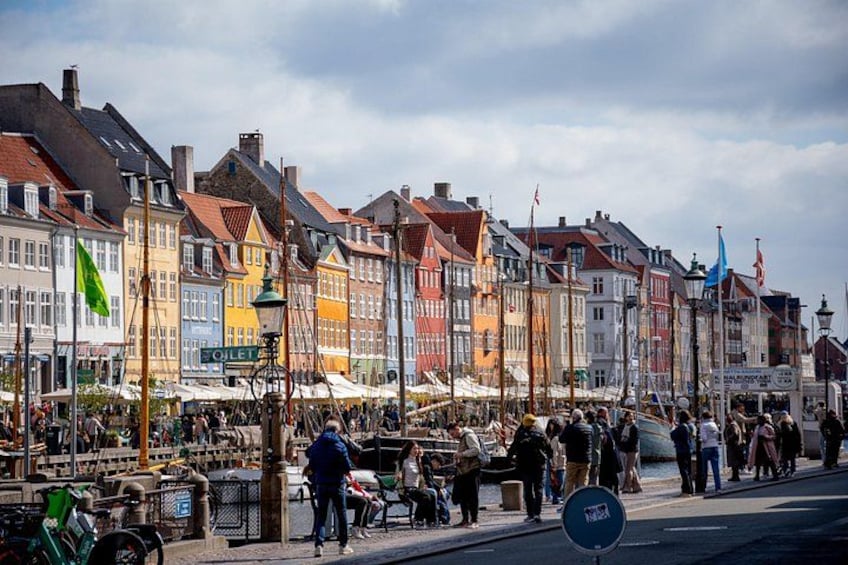 A bustling street market with colorful buildings and people shopping. 1