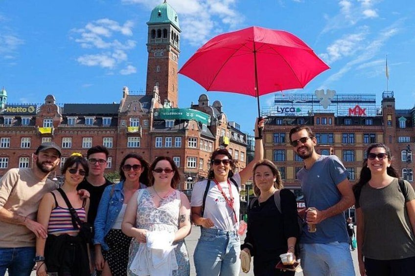 A group of people posing in front of a historic building with a clock tower. 4