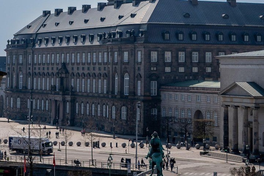 A large historic building with a prominent statue in the foreground. 5