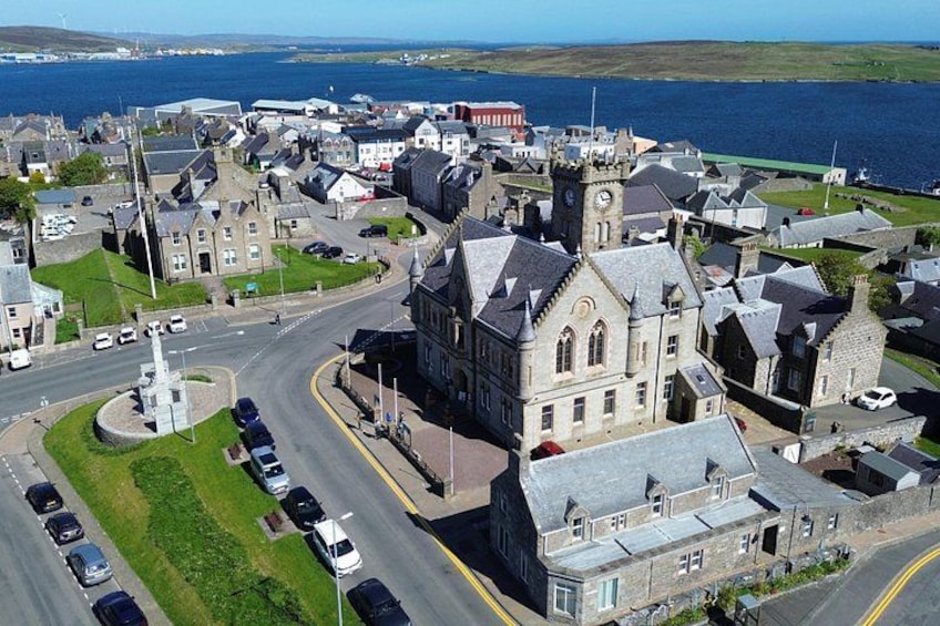 A coastal town with a prominent church, a roundabout, and a bridge in the background. 1