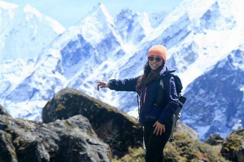 A person standing on a rocky outcrop with a mountainous landscape in the background. 3