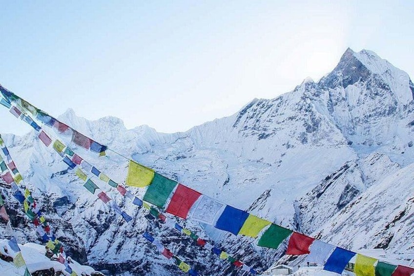 A snow-covered mountain range with colorful prayer flags. 5