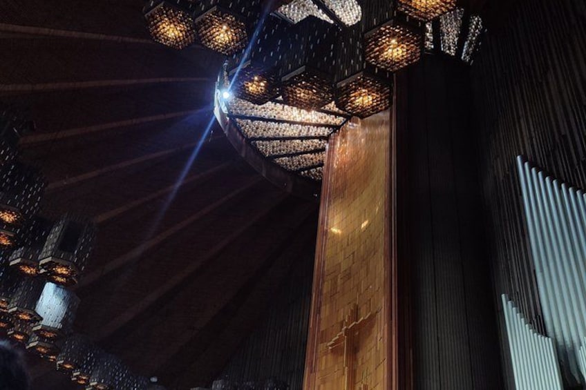 A wooden beam, a metal railing, and a patterned ceiling with hanging lights. 3
