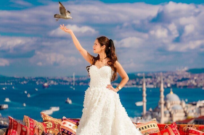 Una persona con un vestido blanco de pie en un balcón, con un paisaje urbano de fondo. 4