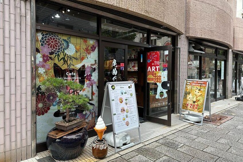 A storefront with a colorful floral window display, a menu board, and a signboard. 2