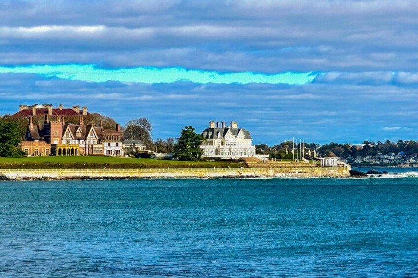 A coastal landscape with a large estate and a body of water. 4