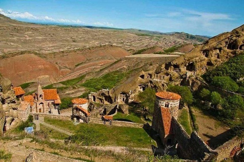 Un pueblo histórico con ruinas antiguas, una torre destacada y construcciones tradicionales. 1