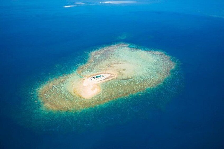 An aerial view of a small island with clear blue waters surrounding it. 2