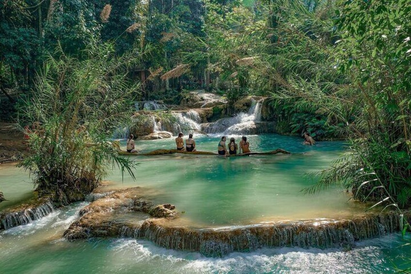 A natural hot spring surrounded by lush greenery and waterfalls. 3