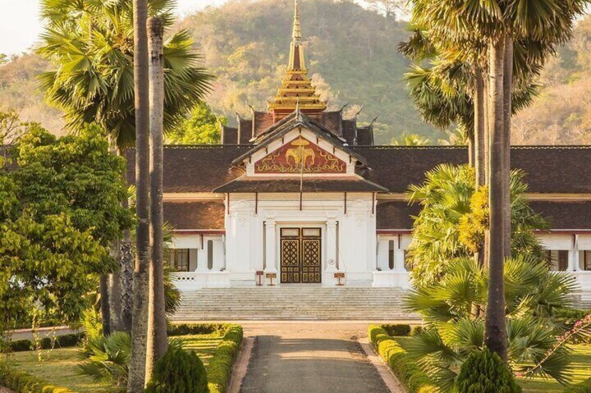 A temple with a golden spire, surrounded by palm trees and a well-maintained garden. 1