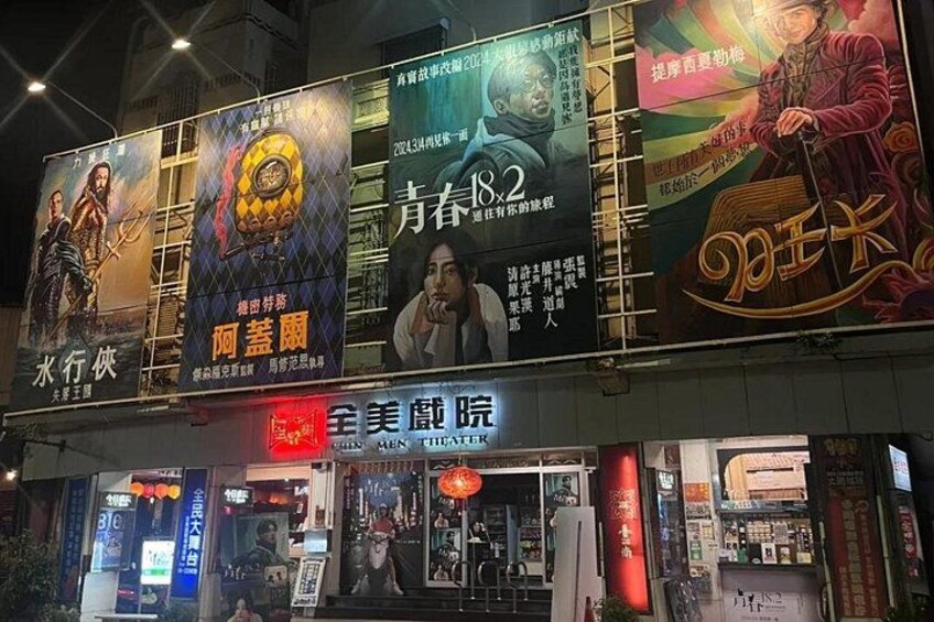Ein Theater mit mehreren Filmplakaten und einem Schild für das All Beauty Theater. 2