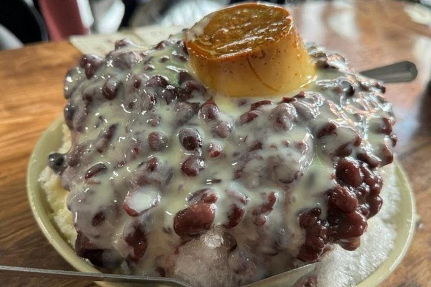 Ein Dessert mit karamellisierter Oberseite, überzogen mit cremiger Soße und roten Bohnen, serviert auf einem Teller. 3