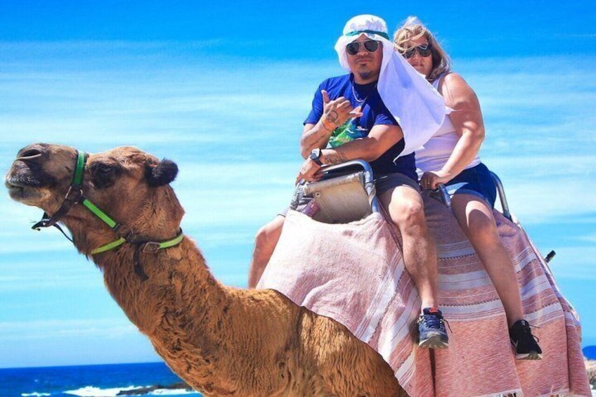 Een kameel met een ruiter en passagier op zijn rug. 4