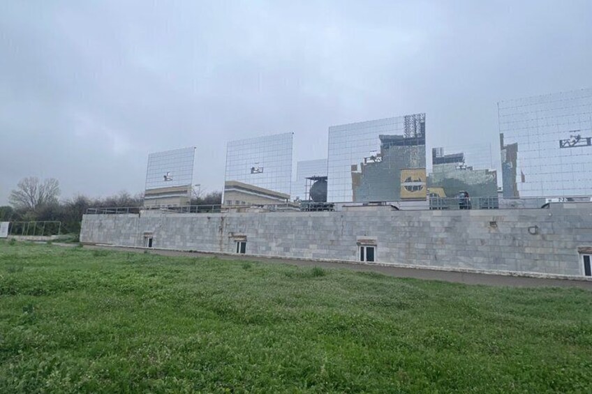 A construction site with multiple buildings under construction and a grassy field in the foreground. 4