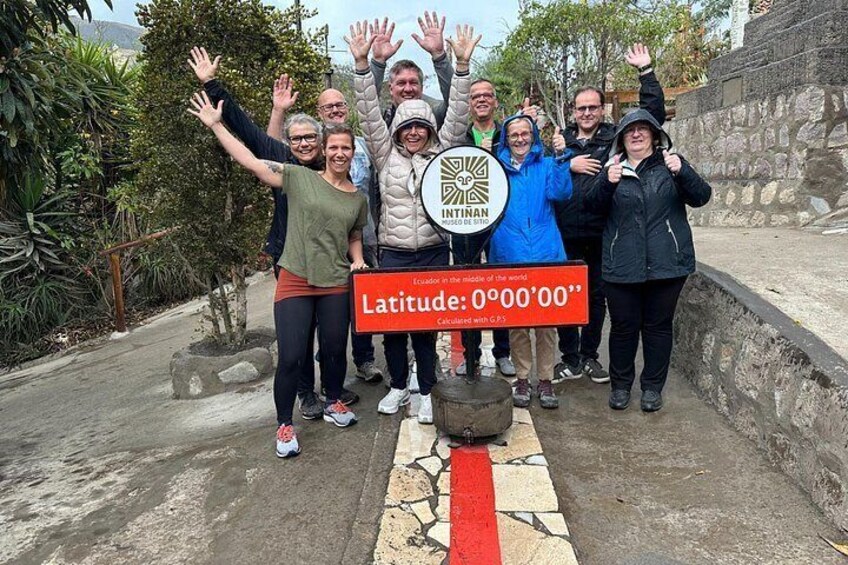 Un grupo de personas en un jardín con un cartel que dice 'Latitude: 0°00'00'. 4