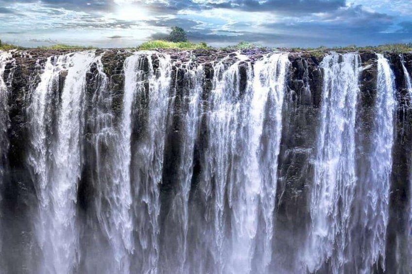 A large waterfall with multiple streams of water cascading down a rocky cliff. 2