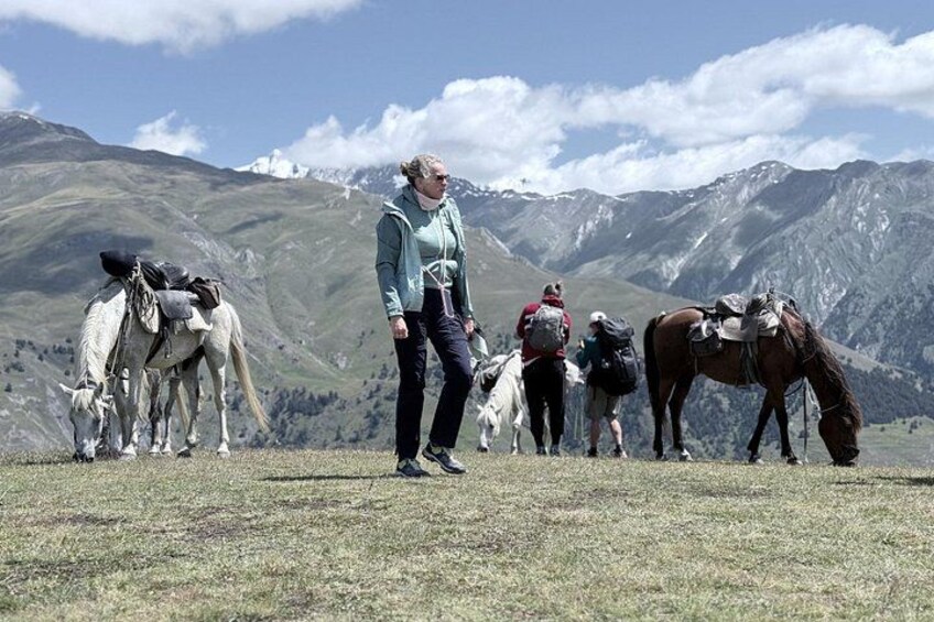 Een wandelaar met een paard en lastdieren in een bergachtig gebied. 3