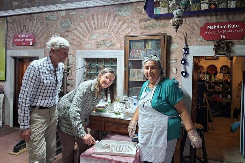 Tres personas en una cocina con una mesa, un ventanal y un letrero sobre la puerta. 5