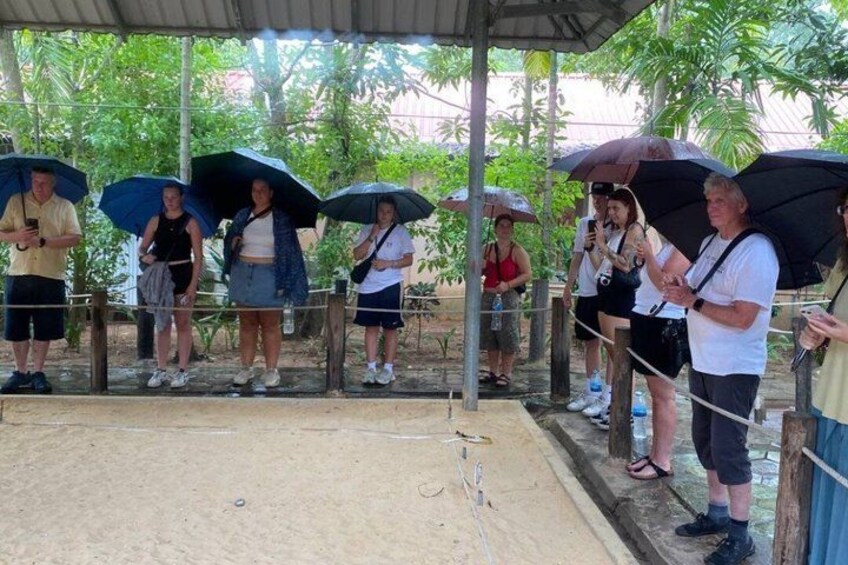 A group of people standing under umbrellas at an outdoor event. 5