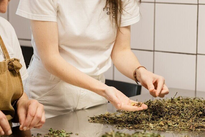 A person handling dried herbs on a kitchen counter. 1