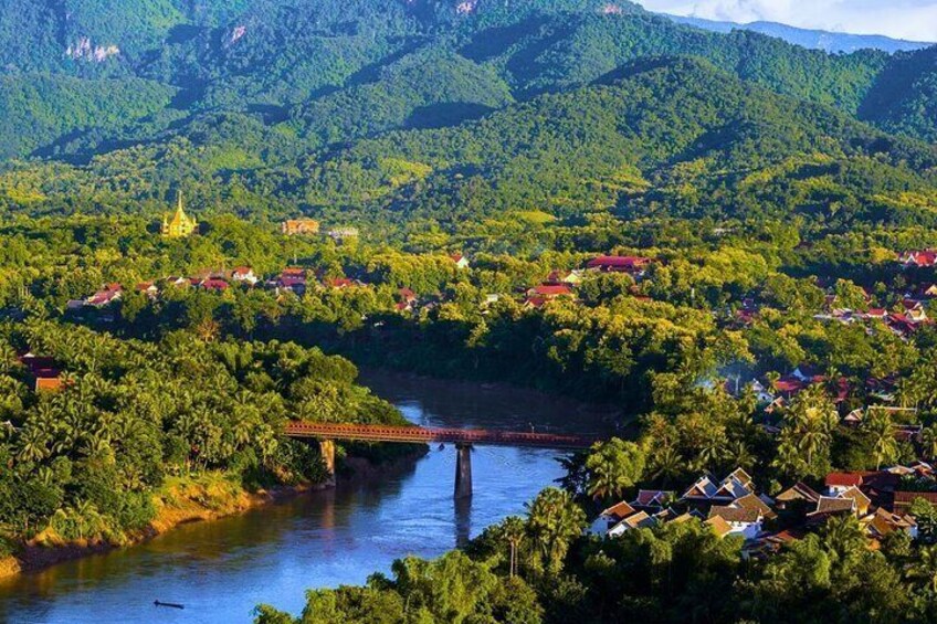 A river with a bridge, surrounded by lush greenery and houses. 2