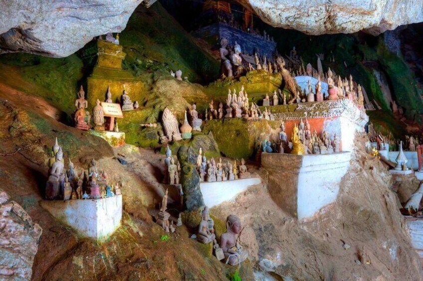 A cave with numerous statues and carvings, including Buddha figures and intricate designs. 3