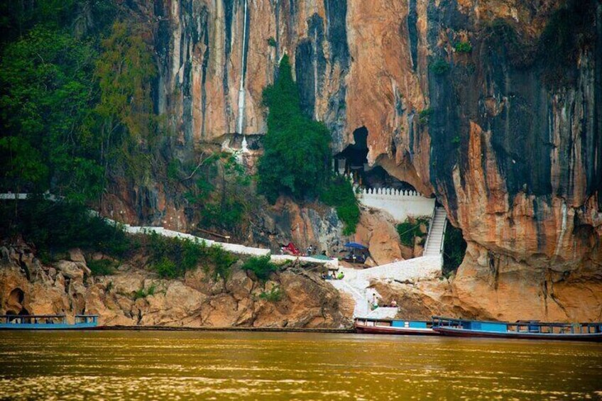 A river with a rocky cliff, a bridge, and a boat. 4