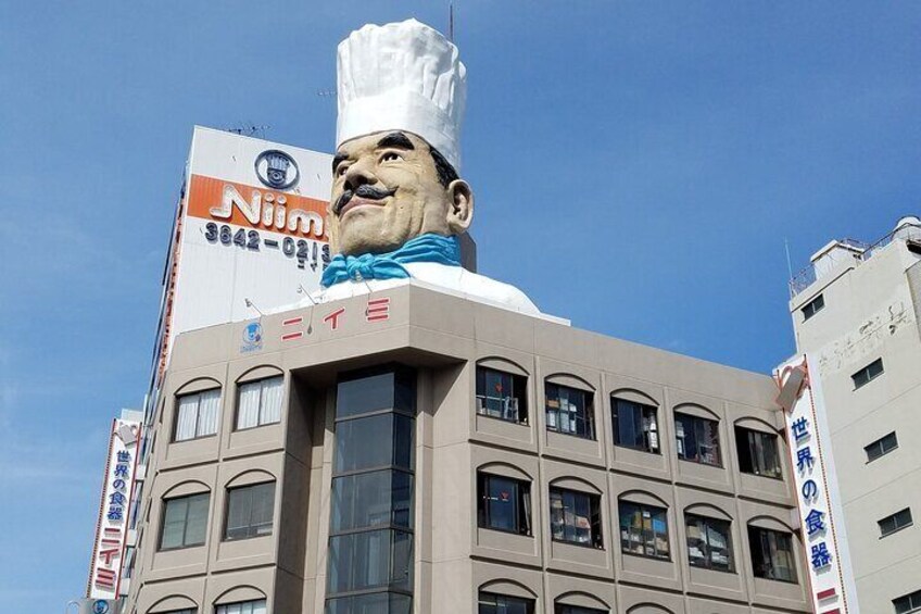Un edificio con una gran estatua de un chef en la parte superior. 4